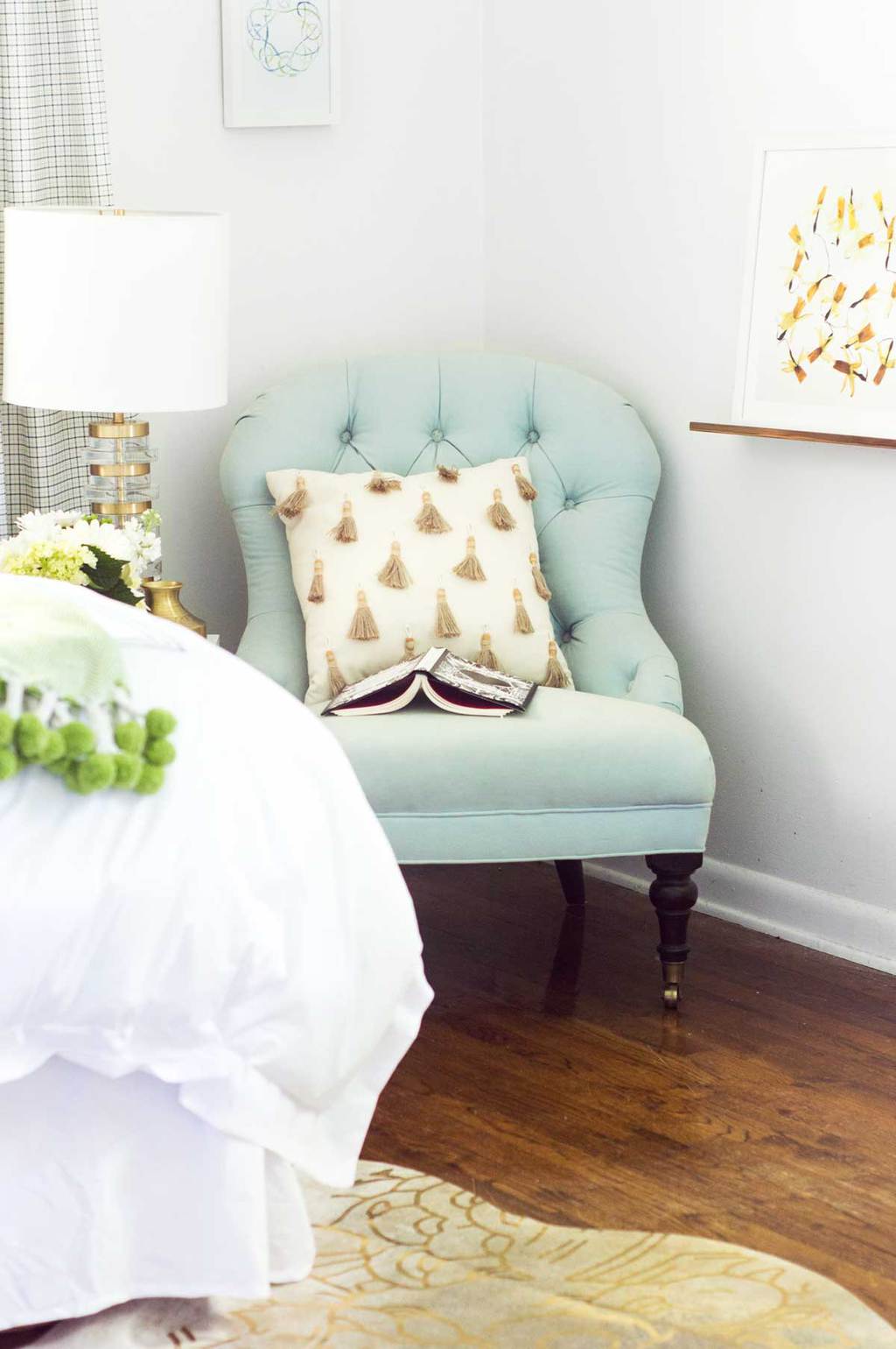 Blue tufted slipper chair with tassel pillow and brass table lamp on Thou Swell @thouswellblog